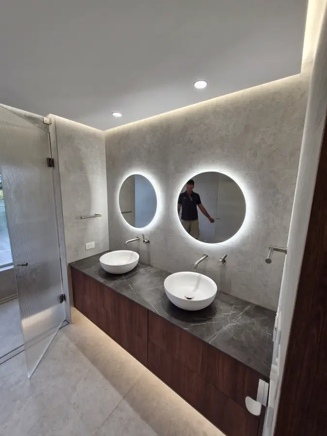 Double vanity bathroom with round backlit mirrors