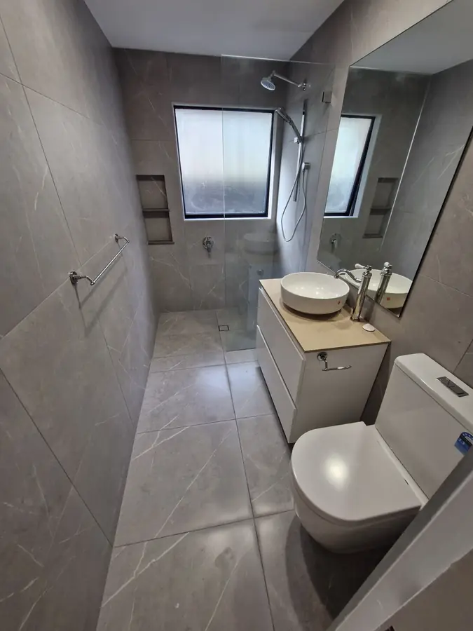 Walk-in shower in large-format grey porcelain tiles