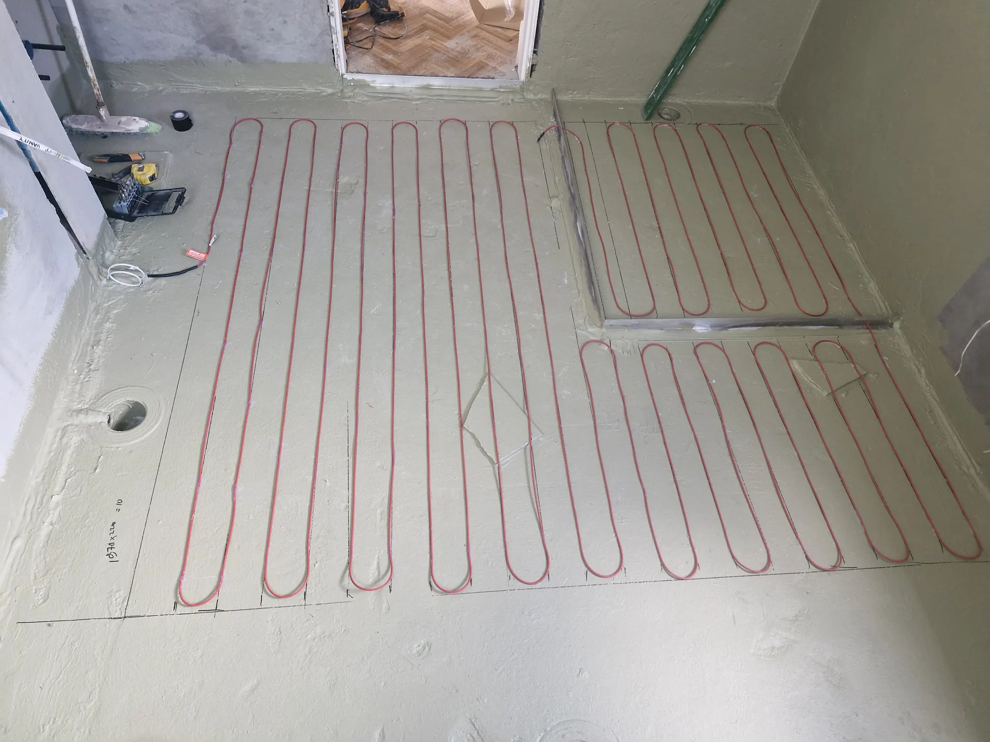 Underfloor heating cable laid out in an even grid before screeding, ready for tiling