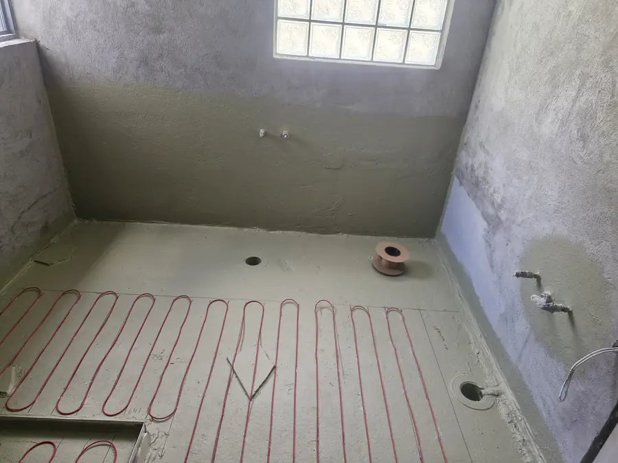 Underfloor heating cable installation in a bathroom being renovated