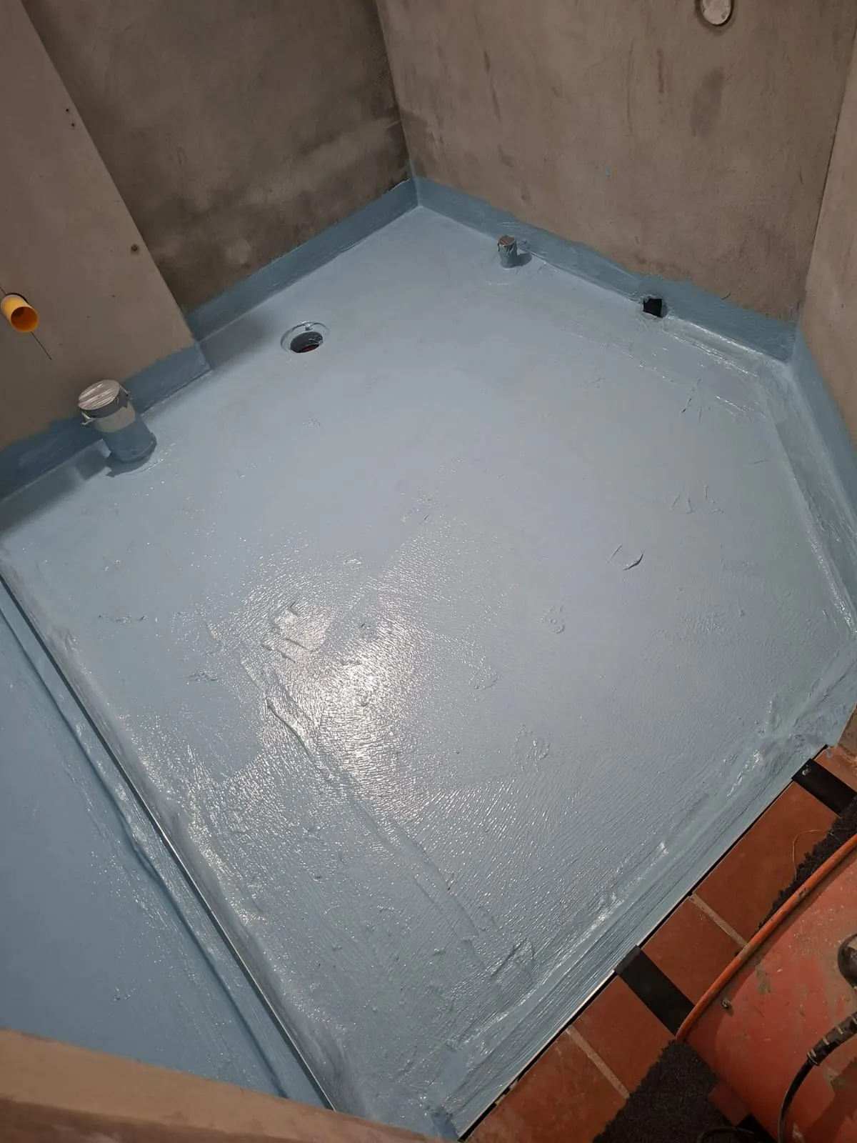 Freshly applied blue waterproofing membrane on a shower wall and built-in niche